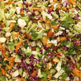 a salad with carrots, celery, onions and lettuce in a white bowl