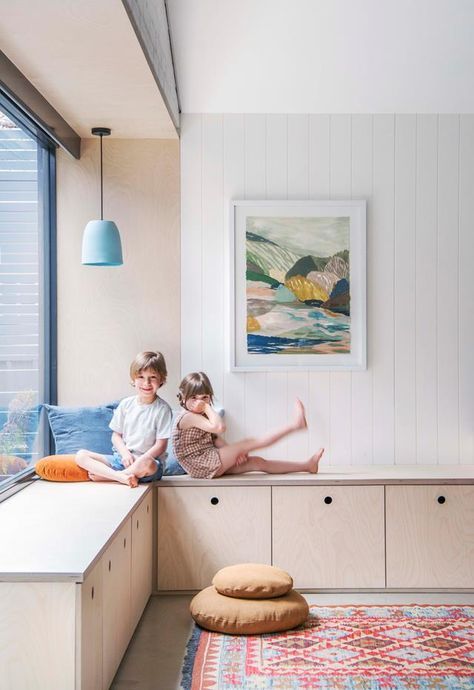 two young children sitting on a window sill