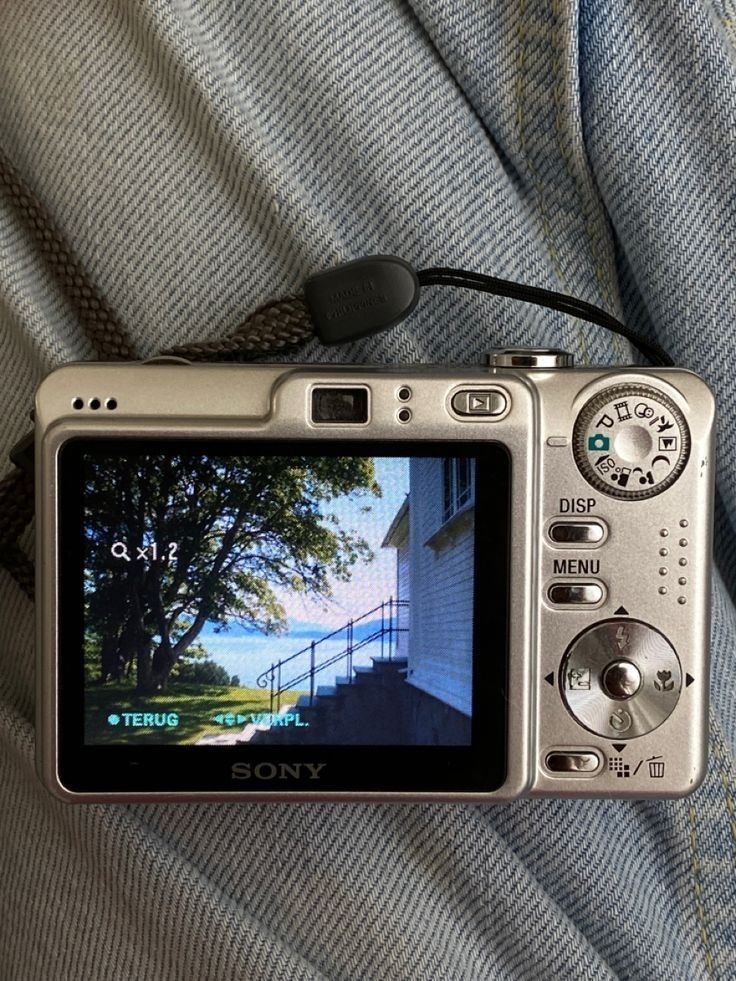 a silver camera sitting on top of someone's lap