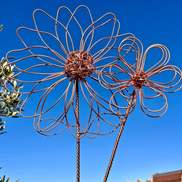 a large metal flower sculpture in front of a blue sky