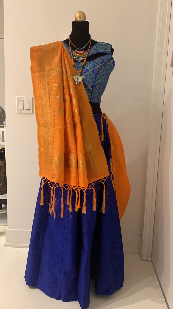 Blue chanya choli with orange dupatta. Blue chanya(skirt) has made up of Tafeta silk. Brocade Blouse with unique pattern of blue and golden threads comes with extra sleeves. Orange dupatta with golden zari threads. Item Contain : Blue and orange chanya choli set Chanya(skirt) Length : 42 Inches Blouse Length : 14.5 Inches Sleeves : Sleeveless (But it has extra sleeves of length 5 Inches) Item In Box: 3 pc outfit Color : Blue ( As Shown In Image ) Fit Type : Regular Fit Occasion: Will add luster when worn for a wedding, engagement, party, prom, navratri(garba) and any special occasion. It will enhance special days like Valentine's Day, Birthdays, Anniversaries and Mother's Day Gift. Color Declaration: There Might Be Slight Variation In The Actual Color Of The Product Due To Different Screen Orange Dupatta, Sangeet Ceremony, Navratri Garba, Navratri Chaniya Choli, Brocade Blouse, Brocade Blouses, Designer Blouse, Chaniya Choli, Silk Brocade