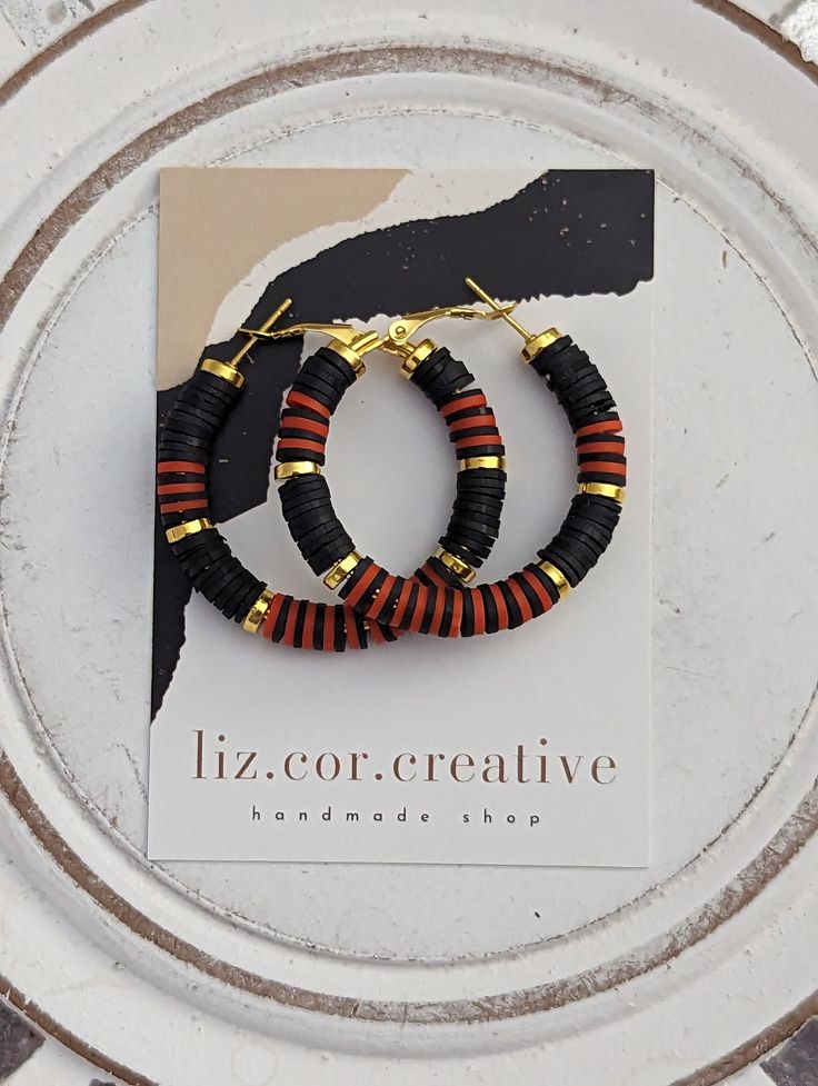 "+ Style name: Boho Stripes + beaded hoop earrings with Black, Orange and Gold heishi beads  + Hoops are 1 1/2\" diameter + gold hoops with lever back closure + All lizcorcreative hoop earrings will come packaged on a hand-stamped kraft earring card in a clear sealed bag Free Domestic Shipping Follow along Instagram https://www.instagram.com/lizcorcreative/ Facebook https://www.facebook.com/profile.php?id=100063235479850 Pinterest https://www.pinterest.com/lizcorrinne/ If there is any other colo Halloween Heishi Earrings, Bohemian Hoop Beaded Earrings With Heishi Beads, Small Black Hoop Earrings For Jewelry Making, Adjustable Hoop Earrings With Black Beads As A Gift, Handmade Black Hoop Earrings Gift, Black Beaded Small Hoop Earrings As Gift, Handmade Black Hoop Earrings For Festival, Heishi Earrings, Handmade Black Hoop Jewelry