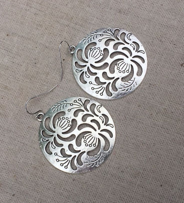 "These are so unbelievably beautiful and stylish! Big silver boho floral disc earrings. They have incredible detail and design. The perfect everyday statement earrings. These are simply gorgeous earrings. Made from allergy free plated silver. The earrings measure 1 5/8\" long by 1 5/8\" long. They hang from simple silver ear wire hooks. Overall drop length is 1 3/4\". I have a matching necklace in my shop if you would like the whole set. Here is a direct link https://etsy.me/3d1P92f Thanks for s Bohemian Flower-shaped Metal Earrings, Bohemian Silver Flower Shaped Earrings, Bohemian Silver Flower Earrings, Bohemian Silver Flower-shaped Earrings, Silver Bohemian Flower Earrings, Silver Bohemian Flower-shaped Earrings, Bohemian Hypoallergenic Flower Earrings, Bohemian Metal Flower-shaped Earrings, Bohemian Sterling Silver Pierced Flower Earrings