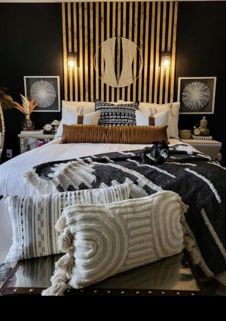 a bedroom with black and white bedding, wooden headboard and decorative artwork on the wall