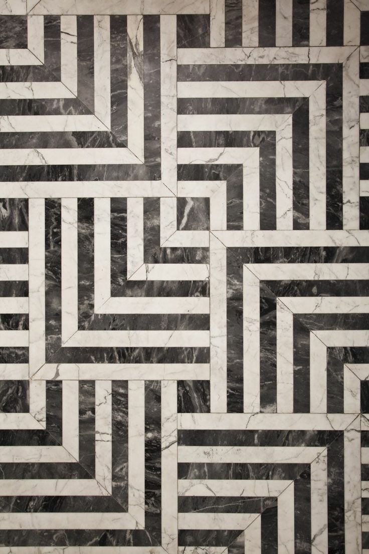 a black and white marble floor with an abstract design in the center that looks like a maze