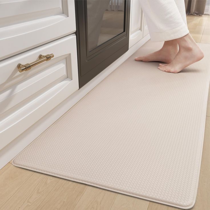 a person standing on a kitchen mat in front of an oven