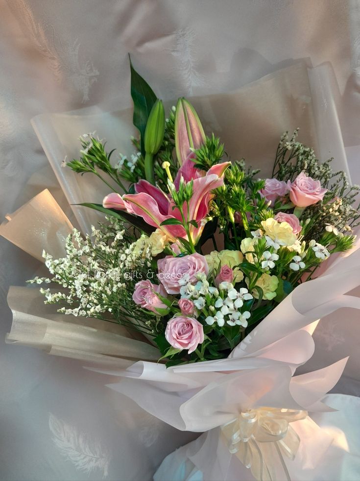 a bouquet of flowers is wrapped in white paper