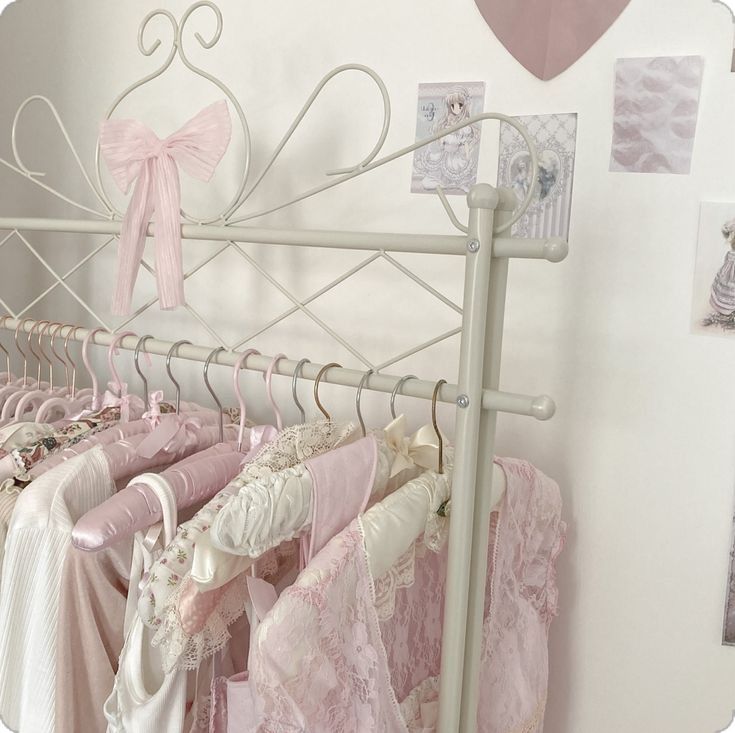 there are many dresses hanging on the rack in this room, and one is pink