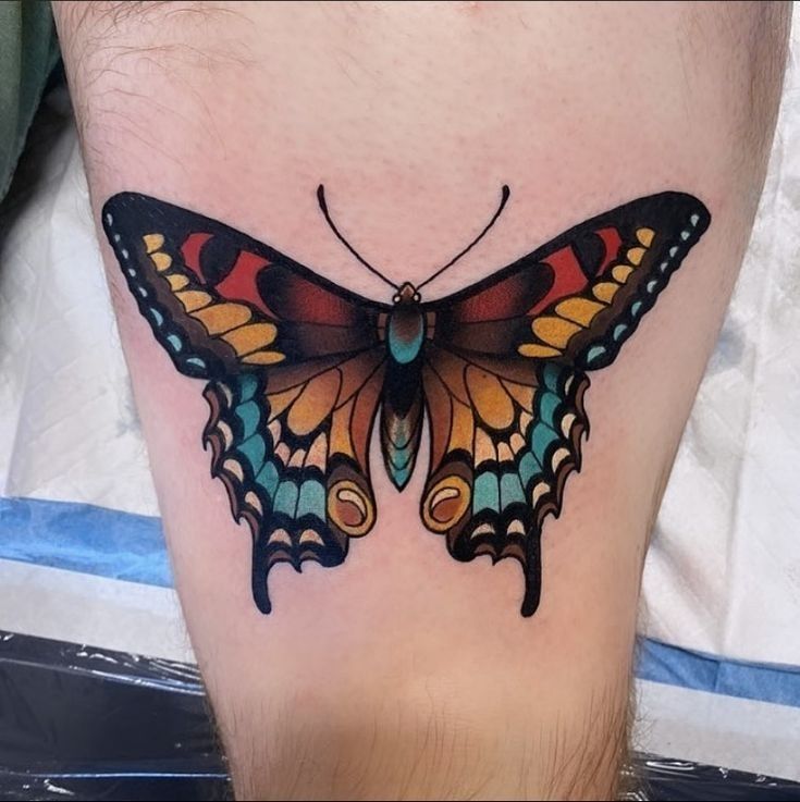 a colorful butterfly tattoo on the leg