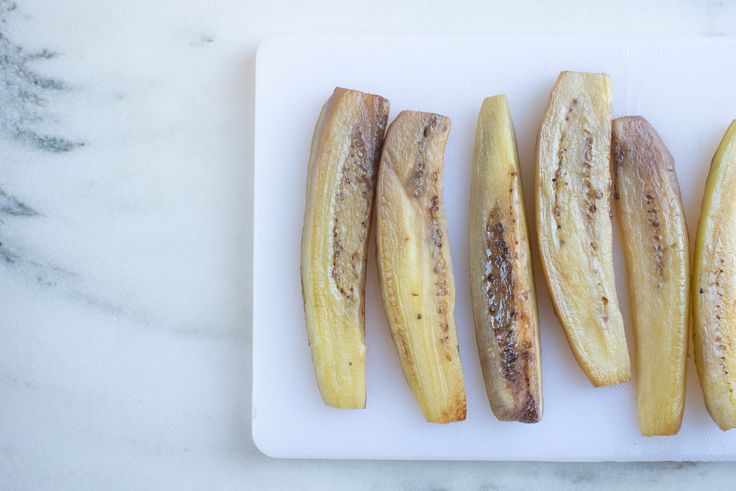 four pieces of banana on a white cutting board