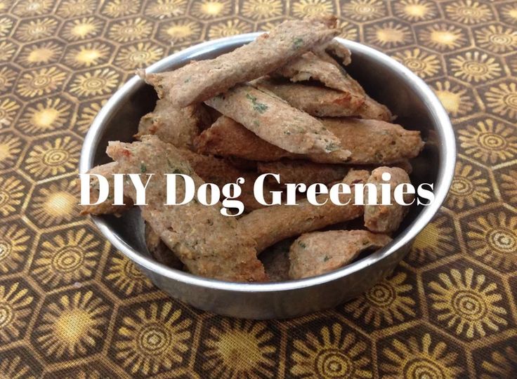 a metal bowl filled with dog treats sitting on top of a patterned tablecloth next to the words diy dog greenies