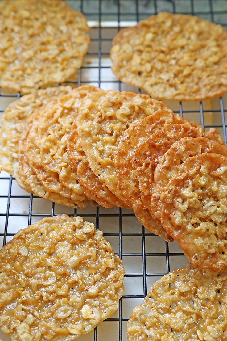 several cookies cooling on a wire rack with some oatmeal in the middle