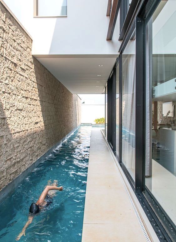 a person swimming in a pool next to a building