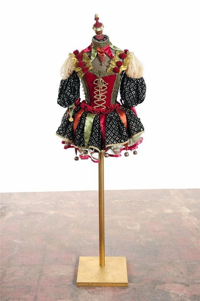 a mannequin dressed in black, red and gold with an elaborate headpiece