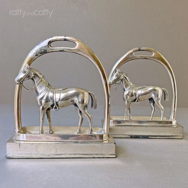 two silver horse figurines sitting next to each other