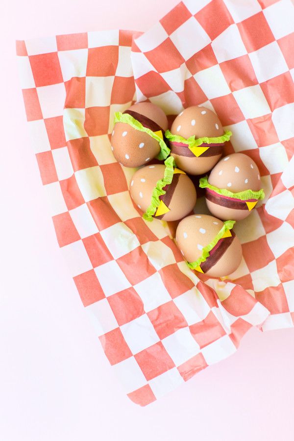 six eggs with green icing in a basket on checkerboard paper, ready to be eaten