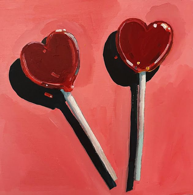 two heart - shaped lollipops on a pink background, one is black and the other is red