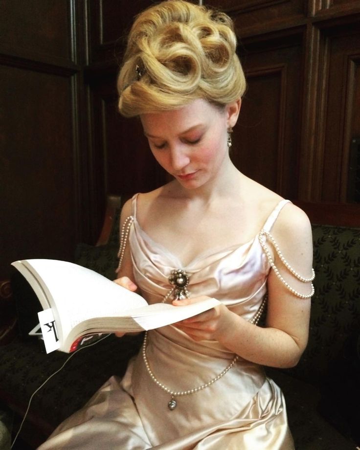 a woman in a dress reading a book