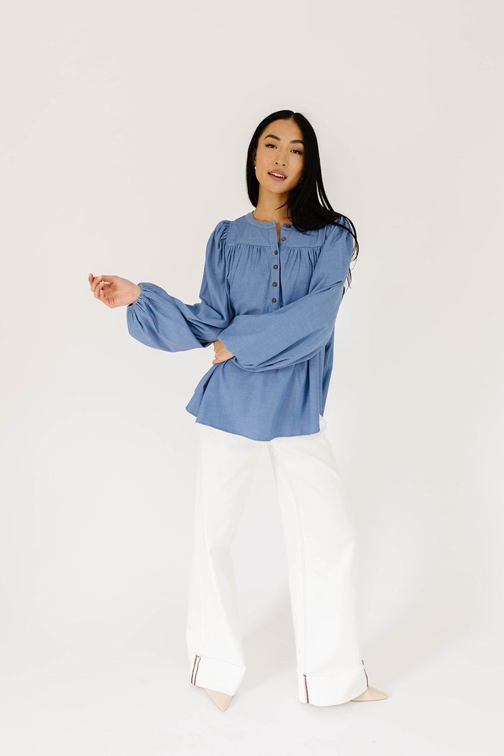 this retro-inspired long sleeve top will take you from summer picnics to fall photoshoots with ease. made with a dark wash denim-esque material, this elevated top features long balloon sleeves + a flowy silhouette. dress it up with trousers + heels, or down with white jeans + sandals. medium wash // high neckline, buttons, balloon sleeves, elastic cuffs paired with our camelot wide leg denim model is 5'8" + wearing a small measurements are approximate + taken while laying flat small : bust 42” l Relaxed Fit Denim Top For Fall, Spring Casual Puff Sleeve Blouse, Spring Trendy Peasant Top With Puff Sleeves, Trendy Spring Peasant Top With Puff Sleeves, Fall Denim Puff Sleeve Top, Denim Blue Top For Fall Day Out, Chic Blue Puff Sleeve Long Top, Chic Medium Wash Denim Top For Fall, Cotton Balloon Sleeve Top For Brunch