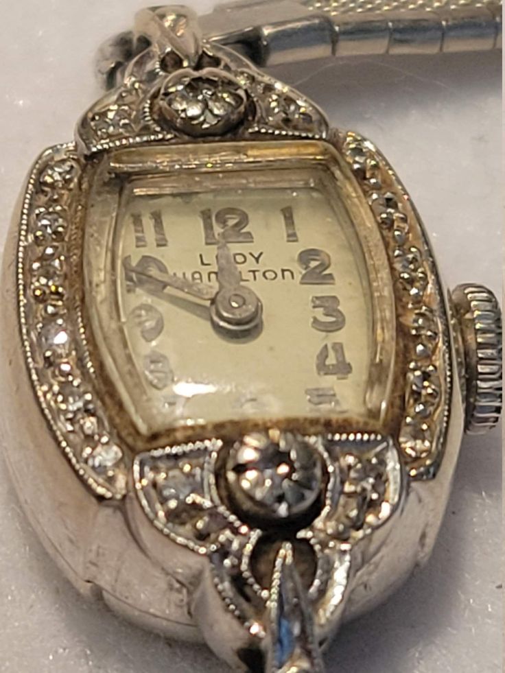 "Vintage \"Lady Hamilton\" 17 Jewel 14K Biggs White Gold Ladie's Wrist Watch, with diamonds.  Admittedly, this needs cleaning up.  Watch runs.  I did not open back to view the mechanism.  Not sure how the back opens, so I devided to just leave it alone.  This was a 25 year service gift for my great aunt, an employee at Callaway Mills in LaGrange, GA.  (It is engraved on the back to her)." Gold Wrist Watch, Lady Hamilton, Art Deco Watch, Vintage Jewelry Ideas, Gold Diamond Watches, Antique Costume Jewelry, Hamilton Watch, Watch Jewelry, Old Watches