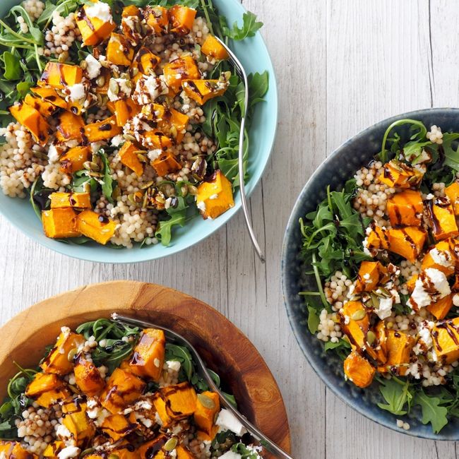 two bowls filled with salad on top of a wooden table