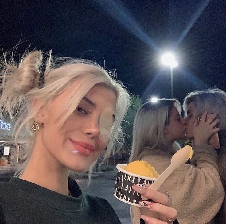 two women standing next to each other holding food