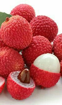 a pile of raspberries next to some leaves