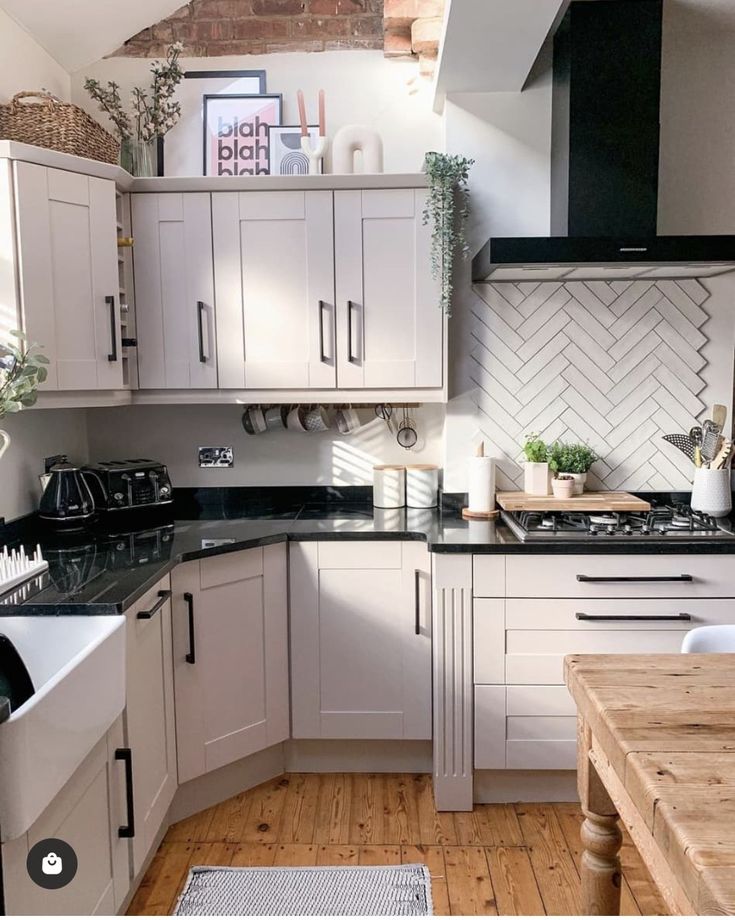 the kitchen is clean and ready for us to use it's counters are white with black counter tops