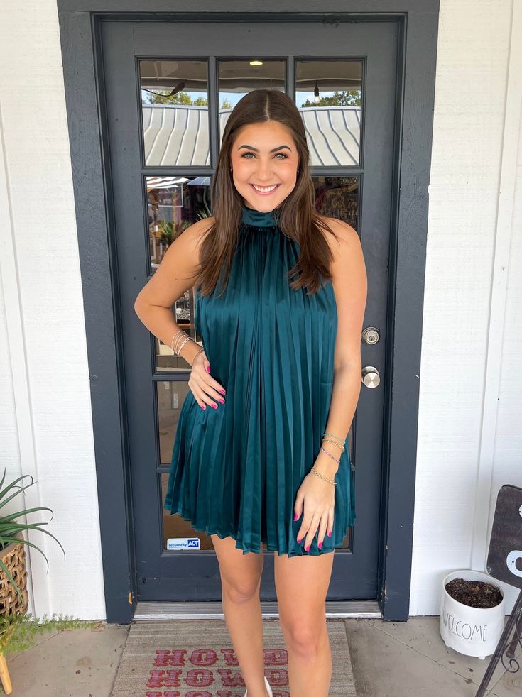 This dress is perfect for any occasion. Constructed with an all-over pleated design and a halter neck with a tie detail, it is both stylish and comfortable. Lined with satin, it is sure to be a go-to in your wardrobe. Thais is wearing a size Medium. Height is 5’10, Bust is 34”, Waist 27”, and Hips 38”. Summer Party Satin Dress With Pleated Bodice, Satin Pleated Mini Dress For Night Out, Pleated Satin Mini Dress For Night Out, Satin Dress With Pleated Back For Date Night, Spring Pleated Satin Mini Dress, Chic Green Halter Dress For Date Night, Chic Pleated Satin Mini Dress, Chic Sleeveless Satin Dress With Pleated Bodice, Spring Halter Neck Satin Dress For Night Out