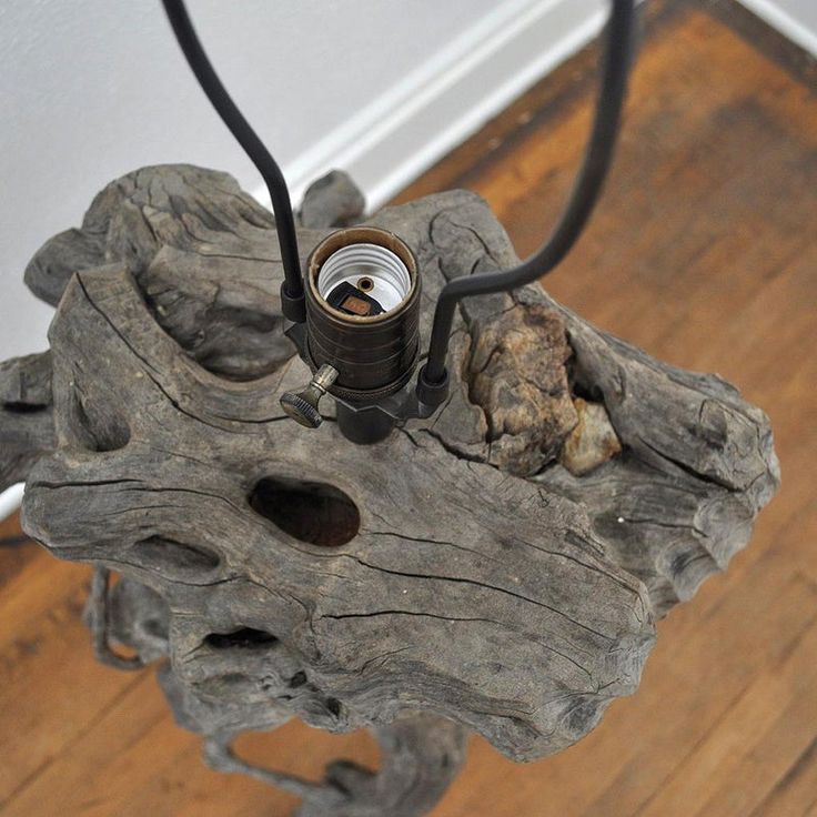 a table made out of drift wood with a light on it and a metal object in the middle