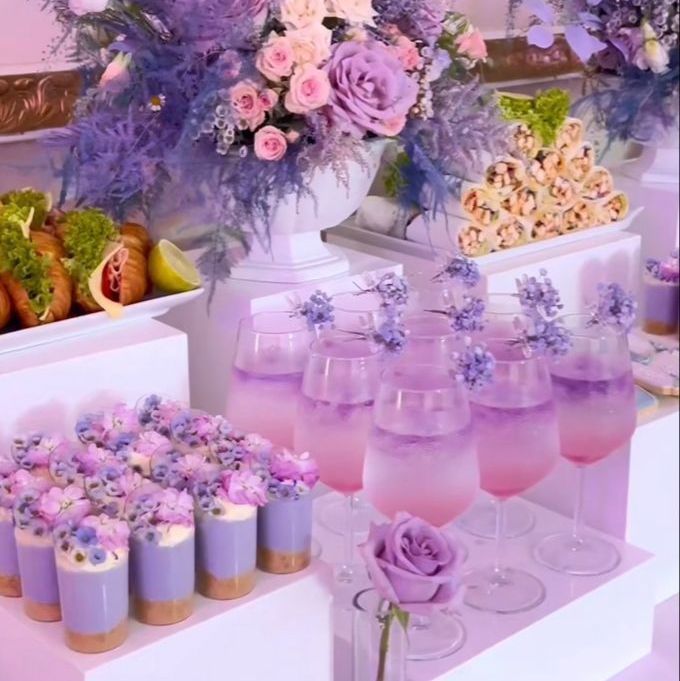 there are many glasses on the table with flowers in them