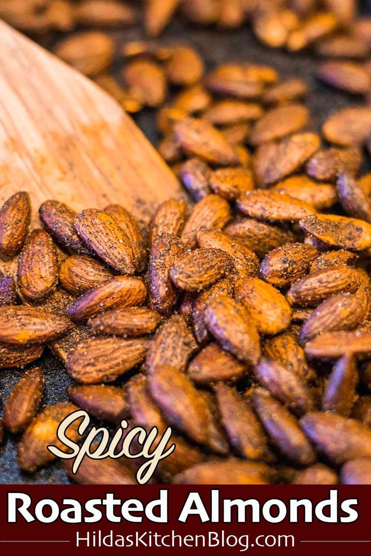 roasted almonds in a wooden spoon with the words spicy roasted almonds