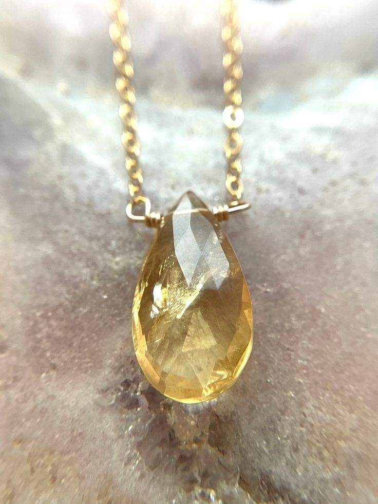 Just like the sun, with its glowing yellow color this handcrafted faceted tear drop citrine pendant necklace is a lovely piece for wearing alone or layering for a stunning statement. The organic and natural variations in this stone’s shape and color are what gives this necklace a true head-turning look. Considered a stone of joy, luck and happiness, feel the warmth and comfort.This citrine necklace will complete your wardrobe and bringing sunshine on any day. Perfect gift for someone you love 🌞 Amber Teardrop Birthstone Jewelry, Faceted Briolette Citrine Jewelry, Teardrop Citrine Jewelry For Gifts, Gold Teardrop Gemstone Crystal Necklace, Teardrop Faceted Citrine Jewelry, Faceted Teardrop Citrine Jewelry, Faceted Citrine Amber Jewelry, Pear-shaped Citrine Jewelry For Gifts, Citrine Teardrop Pendant Jewelry