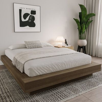 a bed sitting on top of a wooden platform in a bedroom