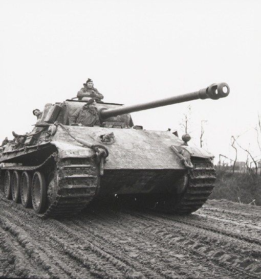 an old tank driving down a dirt road