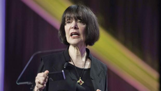 a woman standing at a podium giving a speech