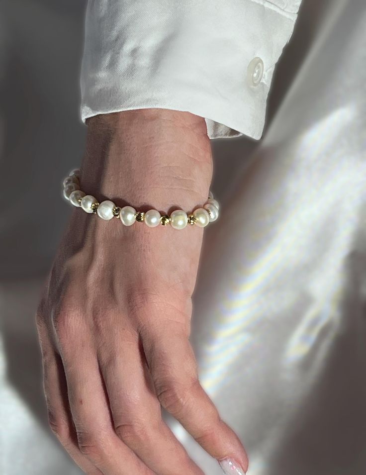 This elegant bracelet features lustrous 6mm pearls, each separated by uniquely shaped beads, creating a stylish and sophisticated accessory perfect for any occasion. The bracelet is made with hypoallergenic findings, all coated with 18k gold, ensuring both beauty and comfort for those with sensitive skin. With a base length of 6 inches and an additional 2-inch extender, this bracelet offers a customizable fit for any wrist size. Details: Material: 6mm pearls with uniquely shaped beads Findings: Hypoallergenic, 18k gold plated Bracelet Length: 6 inches (15.2 cm) Extender: 2 inches (5 cm) Who It's For: This bracelet is ideal for women seeking a stylish and versatile accessory for any occasion. It complements both casual and formal outfits, adding a touch of classic luxury. The hypoallergenic Elegant Pearl White Beaded Bracelets With 8mm Beads, Elegant Pearl White Stretch Bracelet, Elegant Pearl Bracelet With 8mm Beads For Gifts, Elegant Beaded Pearl Stretch Bracelet, Elegant Pearl Beaded Stretch Bracelet, Elegant Pearl White Stretch Pearl Bracelet, Elegant Pearl White Pearl Stretch Bracelet, Elegant Stretch Bracelet With Pearl Charm And Round Beads, Elegant Hand-strung Beaded Bracelets For Parties