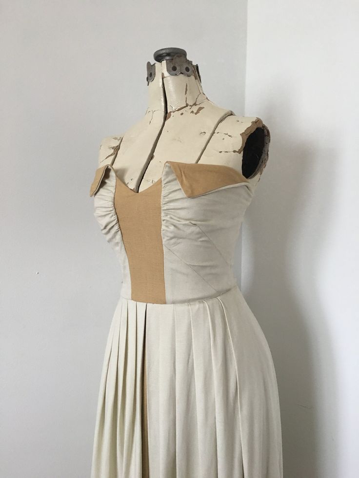 Beautiful vintage dress from the 1940's possibly 1950's. This is a lovely cool dress in neutral tones perfect for summer wedding or day time formal event. The material feels like a heavier cotton or linen material. It drapes nicely and has some soft structure. The bodice has a panel of darker colored fabric (umber, tan, beige, gold beige) in center with gathered bust darts and a dramatic folded neckline with the facing in the same fabric as the center panel. The same fabric runs in a center pane Elegant Fitted Vintage Dress With Sweetheart Neckline, Fitted 1950s Style Vintage Dress For Vintage Events, Fitted Vintage Dress With Sweetheart Neckline, Vintage Cream Dress With Sweetheart Neckline, Chic Fitted Vintage Dress In Beige, Chic Fitted Beige Vintage Dress, Fitted Pleated Vintage Summer Dress, Classic Fitted Vintage Dress For Vintage Events, Elegant Lined Vintage Dress For Garden Party