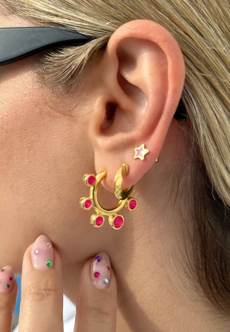 Add a pop of color to your style with these stunning earrings! Each pair features a unique design that will make a statement. The first pair features a large hoop earring with shiny fuchsia enamels that are sure to catch the eye. The middle pair features a tiny gold hoop, adding a touch of sophistication to the mix. And the last pair features a tiny stud earring with a star design and fuchsia enamel that is perfect for everyday wear. These earrings are comfortable to wear and easy to style, maki Vibrant Red Earrings For Gift, Pink Round Pierced Hoop Earrings, Vibrant Pink Jewelry For Gift, Vibrant Pink Jewelry Gift, Vibrant Pink Jewelry For Party, Vibrant Pink Handmade Jewelry, Pink Plug Earrings For Party, Handmade Vibrant Pink Earrings, Vibrant Pink Handmade Earrings