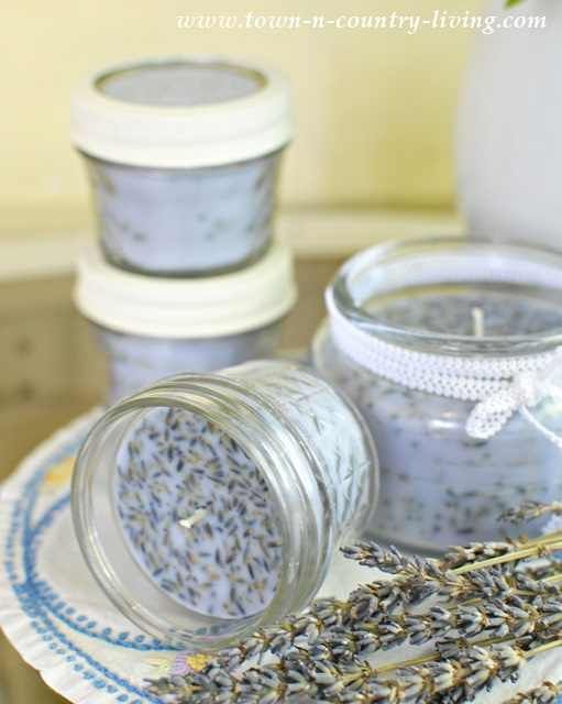 lavender candles are sitting on a plate next to two jars filled with lavenders and other items