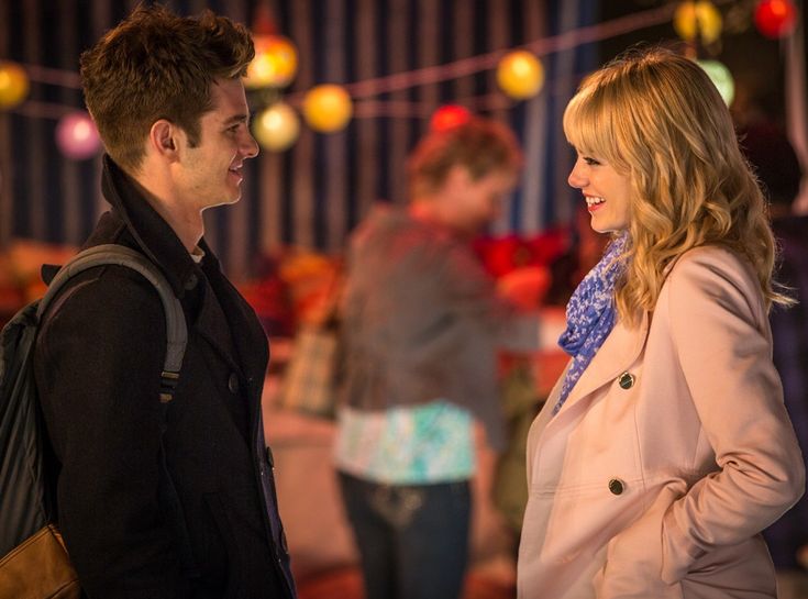 a man and woman standing next to each other in front of colorful lights on the ceiling