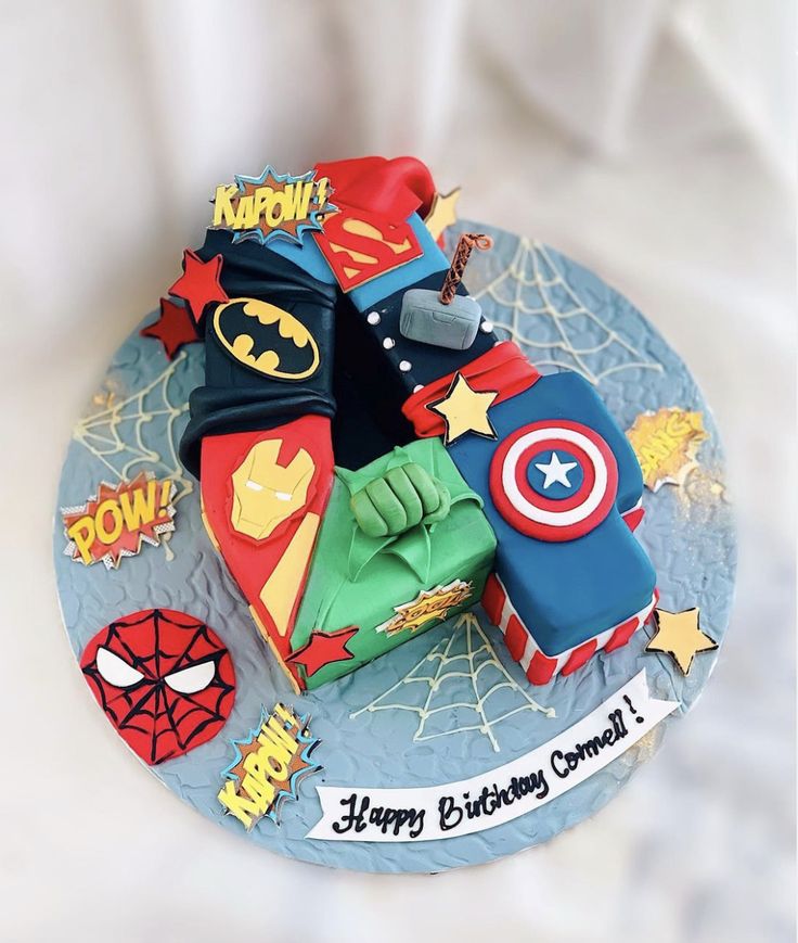 the birthday cake is decorated with superheros and stars