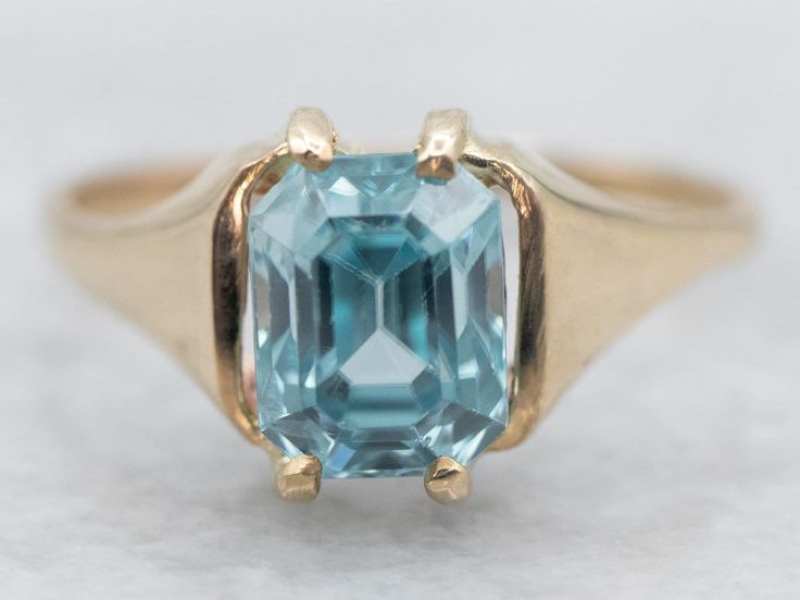 This yellow gold ring is like sunshine on your finger! With its shimmering, emerald cut blue zircon, it's sure to put a sparkle in your eye. So check that box off your wishlist and grab this gold ring before it's too late! *Please note, there are chips on the stone and the piece has been priced accordingly. Metal: 14K Yellow Gold Gem: Blue Zircon 1.93 Carats Gem Measurements: 5.3 x 7.0 mm, Emerald Cut Ring Size: 5 Marks: "VI 14K" Stamped on the inside band SKU #: A32364 Each piece has been ident Blue Topaz Ring With Emerald Diamond Cut, Blue Topaz Ring With Emerald Cut And Diamond Detail, Emerald-cut Blue Topaz Ring With Diamond Cut, Blue Emerald Cut Ring For Birthstone, Blue Emerald-cut Ring With Vvs Clarity, Blue Emerald Cut Ring, Birthstone, Blue Solitaire Emerald-cut Ring, Blue Emerald Cut Ring With Vvs Clarity, Blue Emerald-cut Topaz Ring With Diamond Cut