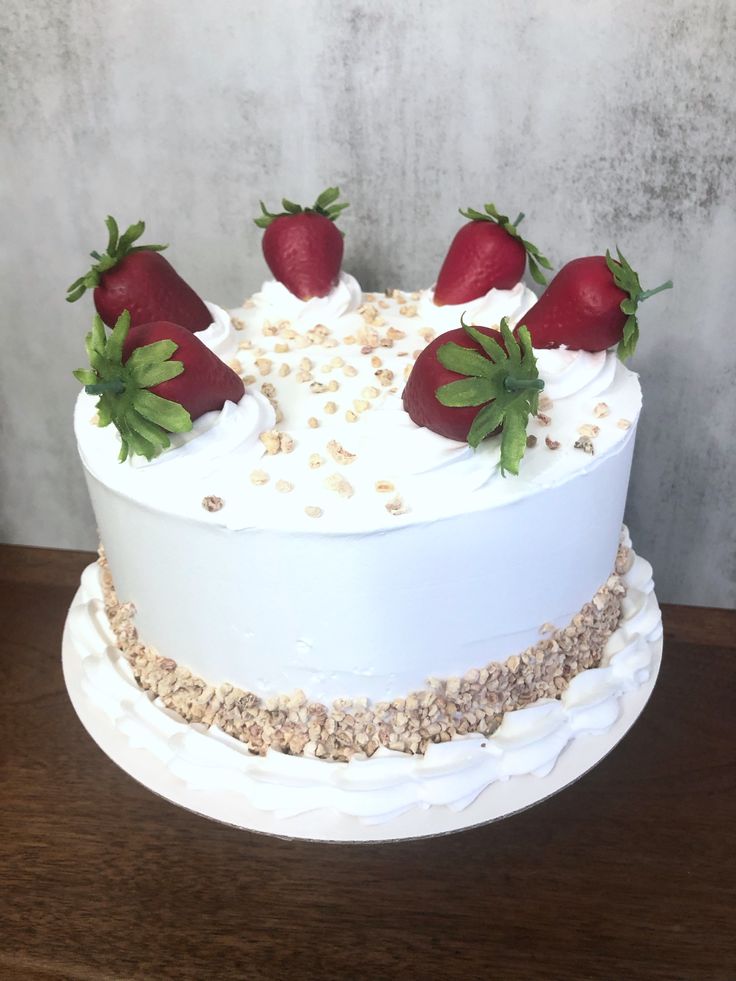 a white cake topped with strawberries and oats