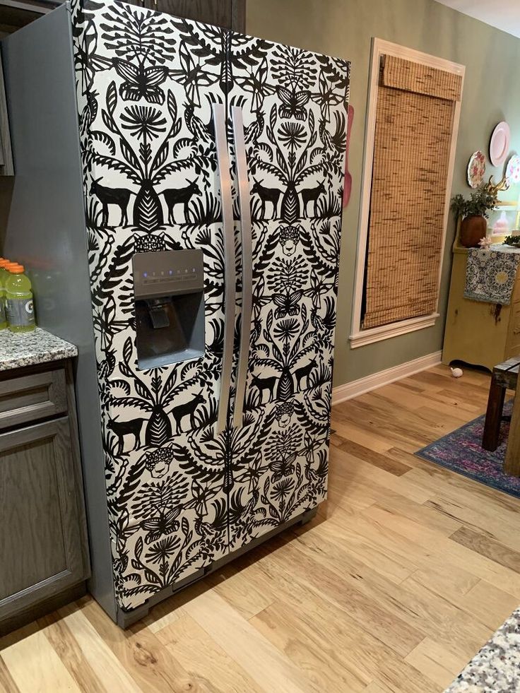 a refrigerator covered in black and white designs