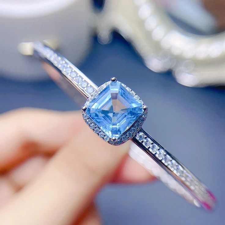 Add a touch of elegance to your outfit with the Topaz Bangle Bracelet. Featuring a stunning Swiss Blue Topaz stone set in a delicate bangle, this bracelet is perfect for any occasion. Its dainty design will make you stand out from the crowd and it's sure to become your go-to accessory. Add some sparkle to your look today and get the Topaz Bangle Bracelet! ----------- DESCRIPTIONS -----------▪Gemstone: Natural Swiss Blue Topaz▪Stone Shape: Asscher▪Gem Size: 8*8 mm▪SKU: FME - B062▪Base Metal: 925 Eternity Bracelet, Topaz Bracelet, Blue Topaz Bracelet, Blue Topaz Stone, Crystal Hoop Earrings, Nose Rings Hoop, Topaz Stone, Swiss Blue Topaz, Fashion Jewelry Earrings