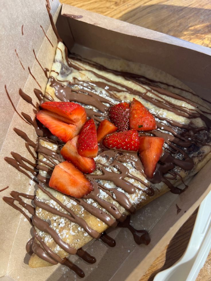 some strawberries are on top of chocolate drizzled and sitting in a box