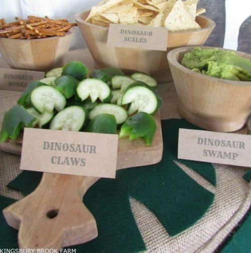 several wooden bowls filled with different types of food on top of a green table cloth