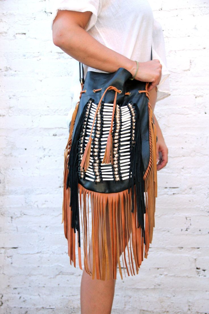 Boho style fringed leather bag black with tan fringes and white bone choker Bone bead choker attached as decoration Fully lined inside with one pocket. strap can be adjusted to several lengths. Material: leather, cow bones 26 cm wide,39 cm long. total long include leather fringes 60 cm Best finishing quality Please note that our products are handmade with some natural materials. For this reason the used materials such as leather and feathers may have slight variations in color. Please do not for Chic Brown Hobo Bag With Tassels, Chic Brown Fringe Hobo Bag, Black Bohemian Shoulder Bag With Tassels, Black Bohemian Bag With Fringe, Bohemian Brown Bag With Beaded Fringe, Black Bohemian Hobo Bag, Black Fringed Shoulder Bag For Festival, Black Fringe Shoulder Bag For Festival, Black Tasseled Hobo Bag