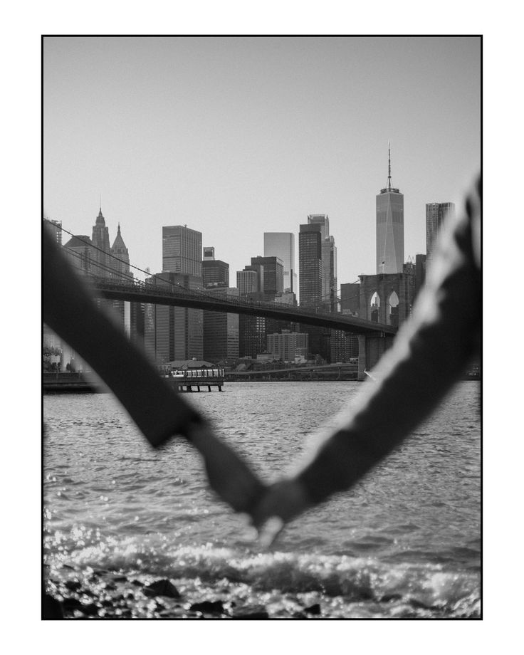 a black and white photo of the brooklyn bridge in new york city taken from across the river